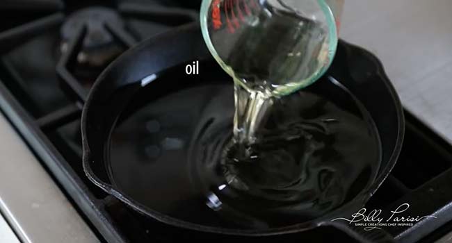 adding oil to a cast iron skillet
