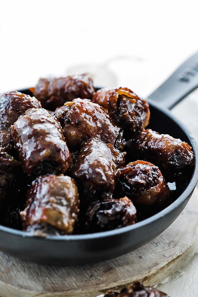 skillet full of bacon wrapped dates