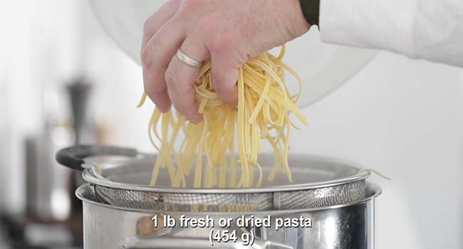 adding fresh pasta to a pot of boiling water