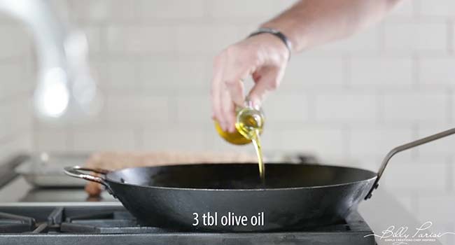 adding oil to a cast-iron skillet