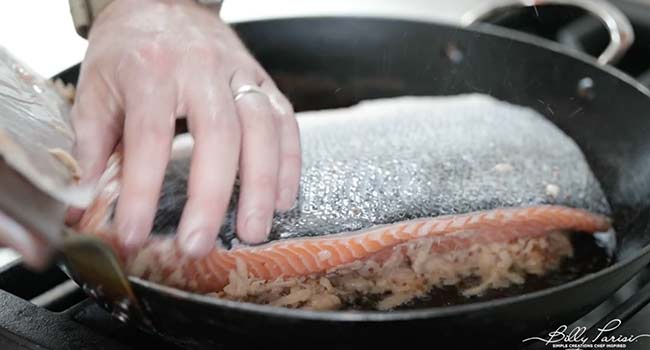 putting potato crusted salmon into a pan