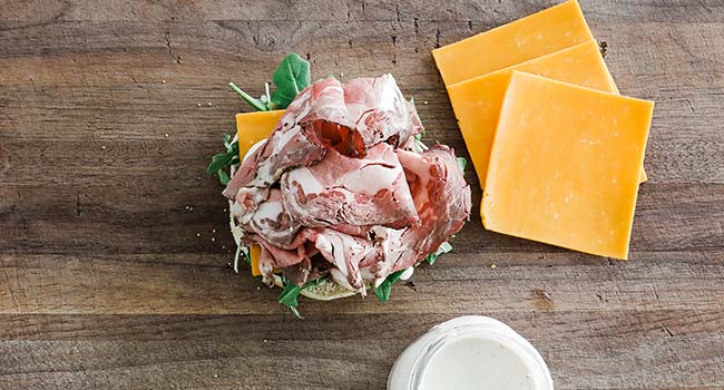 slicing roast beef on a sandwich