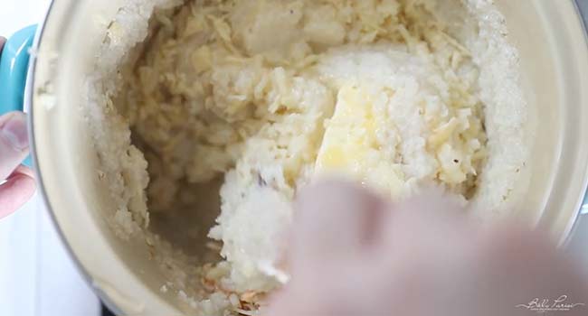 stirring butter into grits