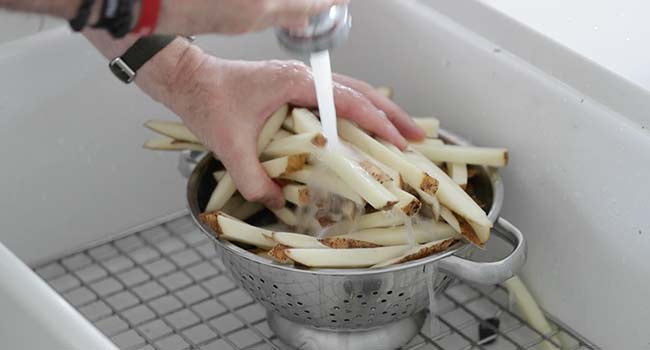 rinsing cut fries under water