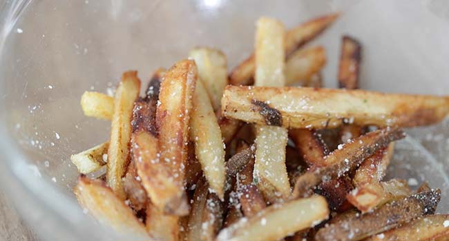 coating pommes frites in parmesan cheese and truffle oil
