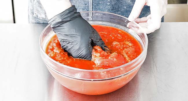 hand crushing tomatoes