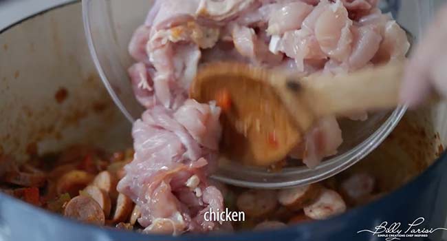 adding chicken to a pot