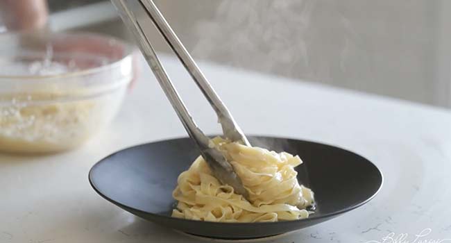 adding pasta to a bowl