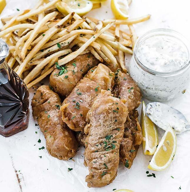 battered fried fish with lemons and fries