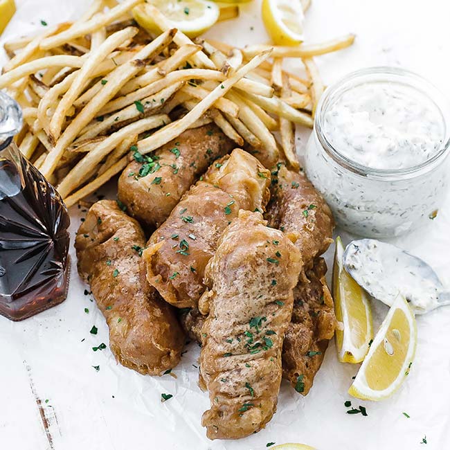 battered fried fish with lemons and fries