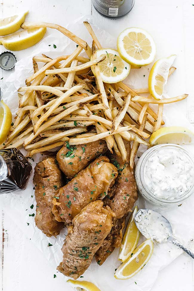 french fries, fried fish, lemons and tartar sauce