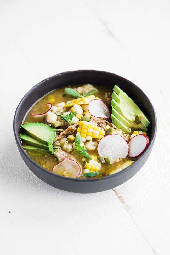 pork pozole soup with a verde broth and topped of with pepitas and oregano