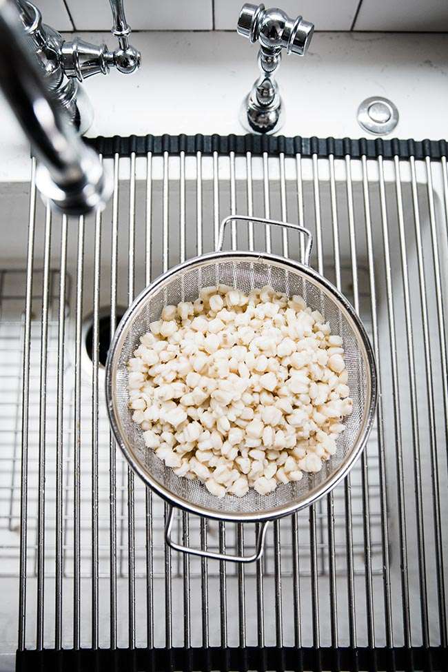 hominy draining in the sink in a colander 