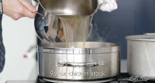 adding chicken stock to a pan
