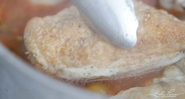 adding chicken to rice and chicken stock