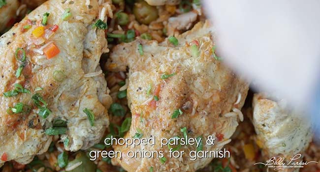 garnishing arroz con pollo with green onion and cilantro