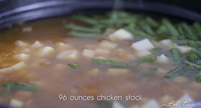 adding vegetables and stock to a pot