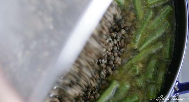 pouring lentils into soup