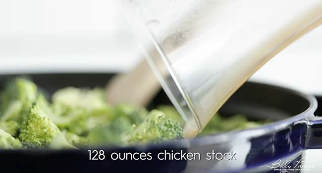 adding chicken stock to a pot with broccoli