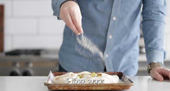 sprinkling sugar onto an apple galette