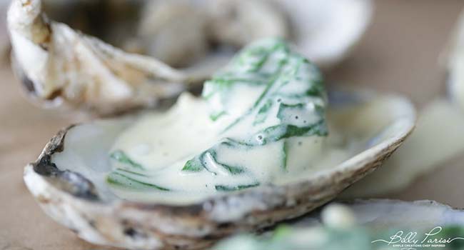 placing creamd spinach to an oyster