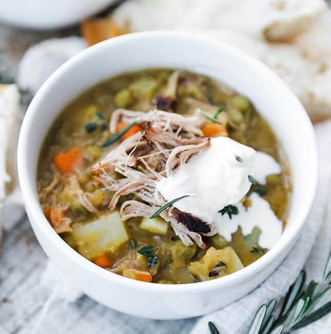 bowl of pea soup with shredded pork and creme fraiche