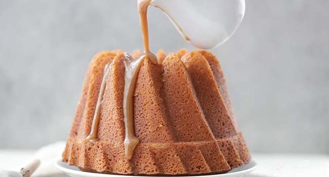 adding caramel sauce to a bundt cake