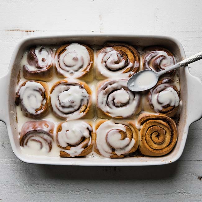 easy overnight cinnamon rolls recipe in as casserole dish with a spoon