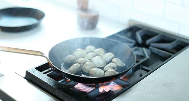 sautéing fresh clams in a pan