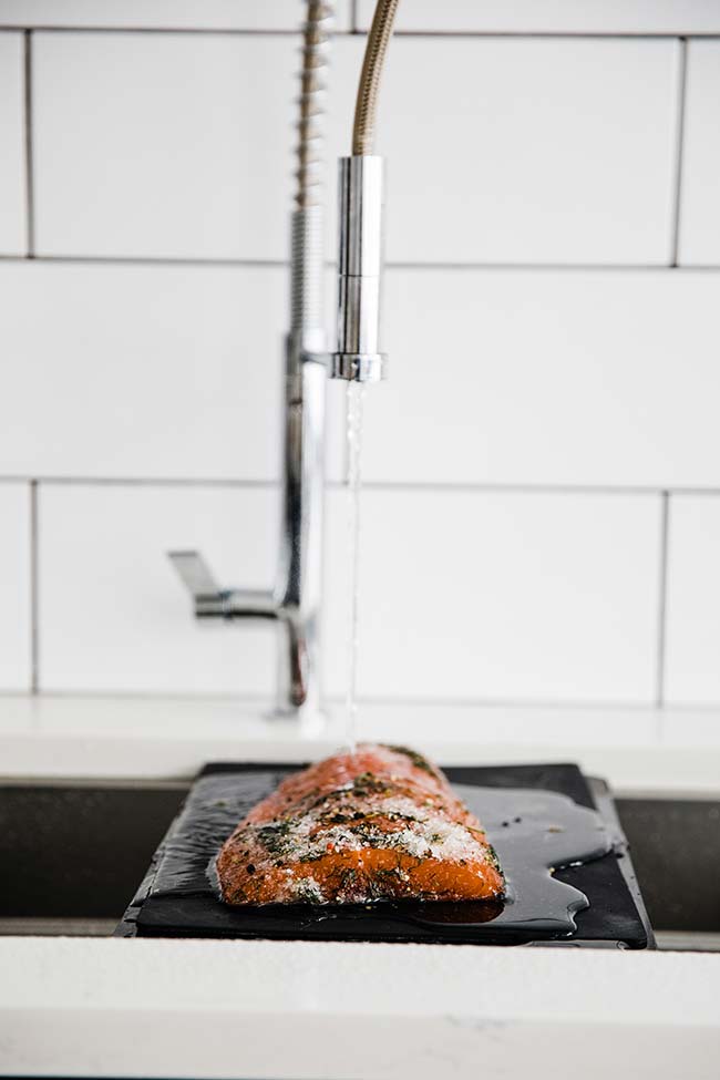 rinsing off the salt cured salmon in the sink