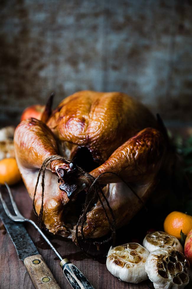 delicious smoked turkey recipe with carving fork and knife on a slicing board