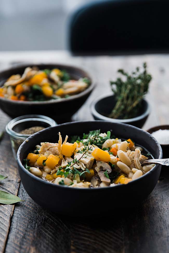 chicken detox soup with beans and kale in a bowl with a spoon