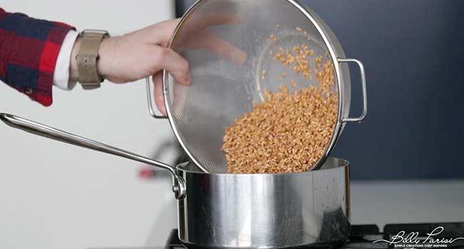 adding rinsed farro to a pot