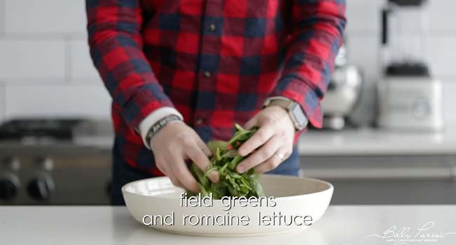 adding greens to a bowl