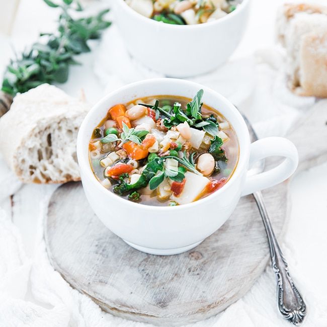 italian minestrone soup recipe with vegetables, herbs and fresh bread
