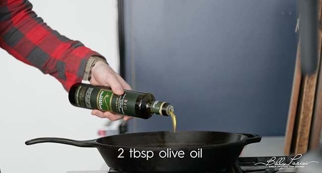 adding oil to a cast iron skillet