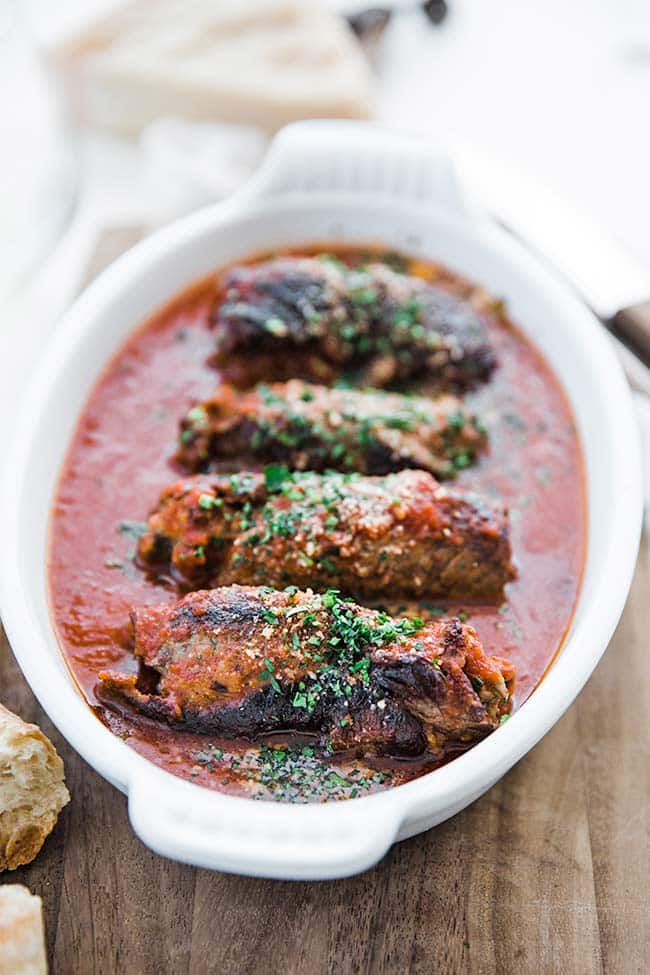 rolled seared beef in tomato sauce in a casserole dish