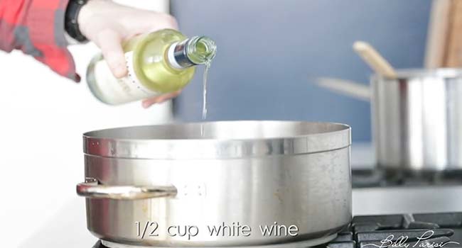 adding wine to a pot