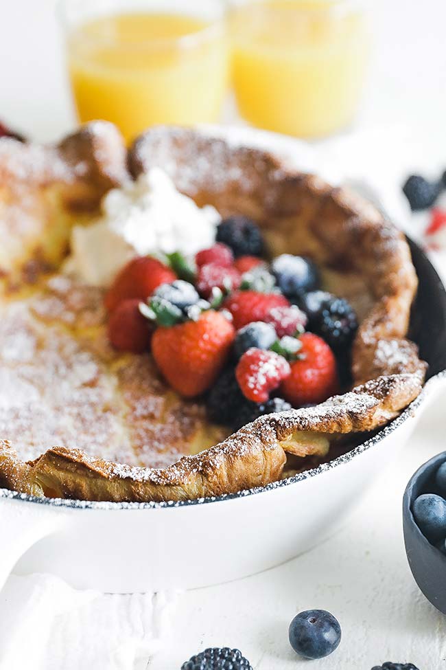 dutch baby in a skillet with fresh berries