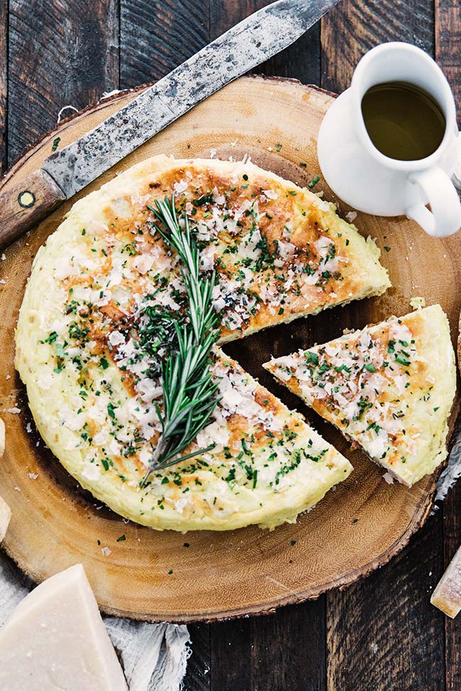 sliced frittata with olive oil, parmesan cheese and fresh herbs