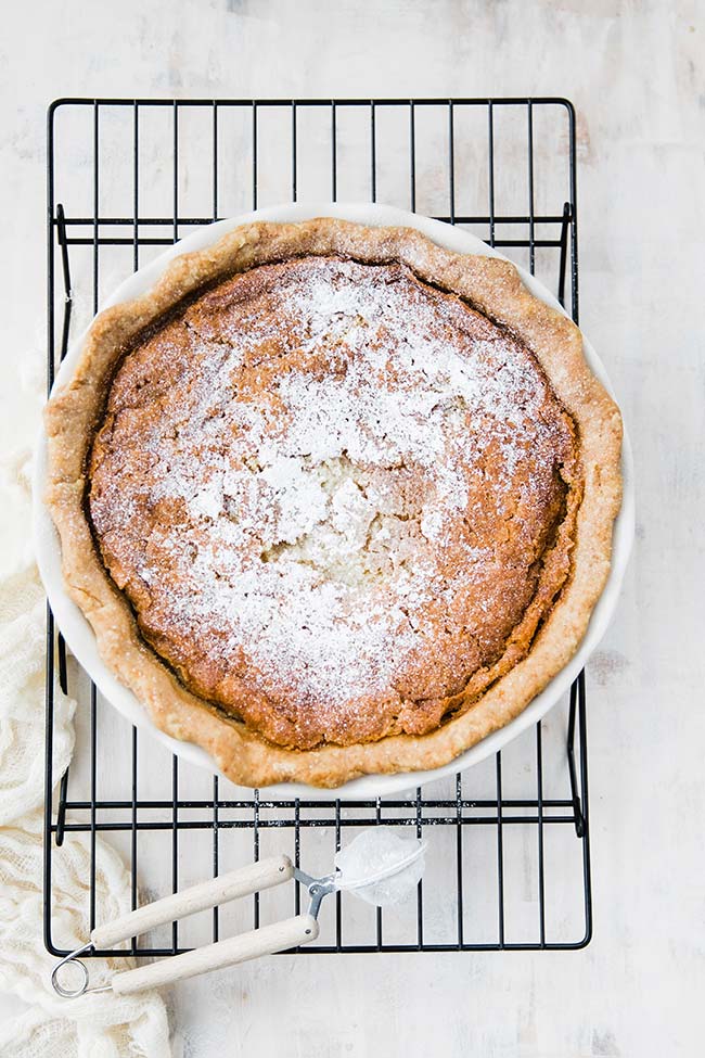 pie cooking on a rack that is dusted with flour