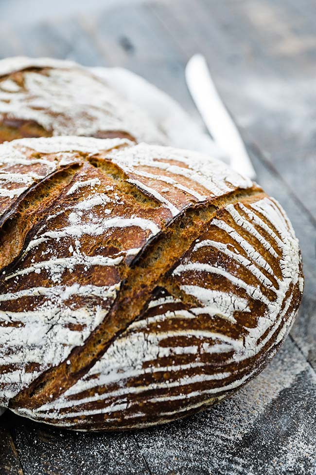 scored baked graham bread recipe on dark cutting board
