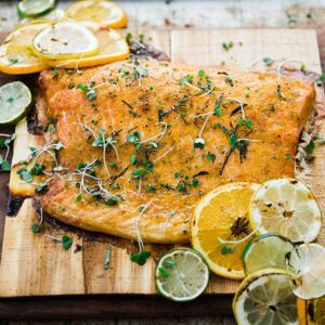 cooked salmon on a cedar plank wit herbs and ctirus