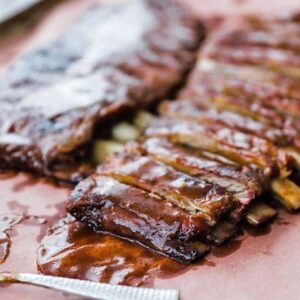 sliced ribs on peach paper with bbq sauce
