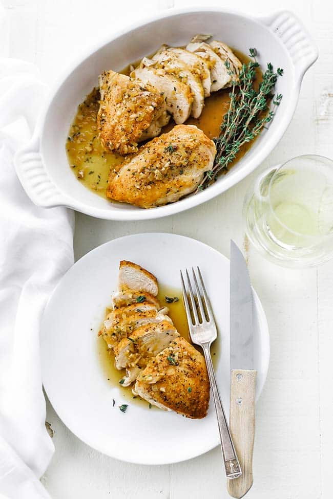 casserole dish of sliced chicken with a plate of sliced chicken