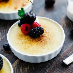 creme brulee in a dish with fresh berries and mint