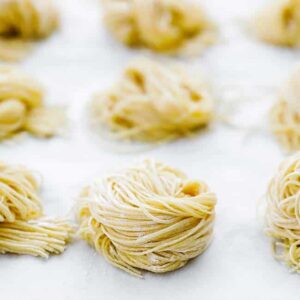homemade pasta curled up in a ball on parchment paper
