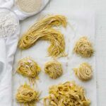 different pastas curled up on parchment paper