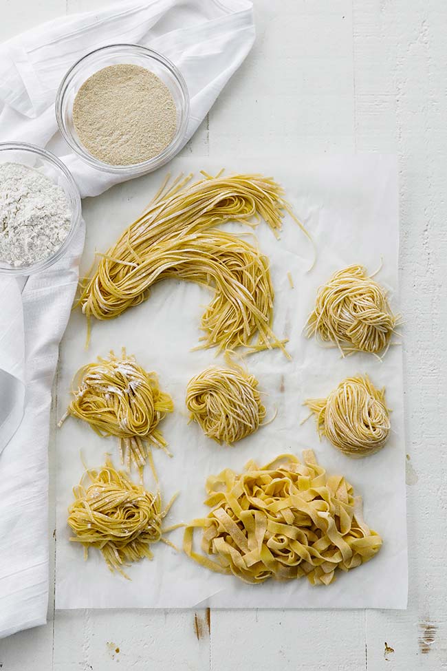 different pastas curled up on parchment paper