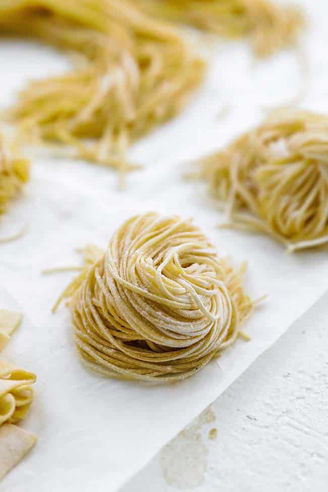 curled up raw spaghetti noodles on parchment 